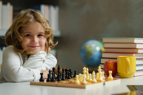 Chess game for children. Shool kid playing chess in classroom. Brain development and logic