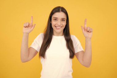 Kadın fotokopi alanını işaret ediyor. Kopyalama alanı yukarı bakıyor. Promosyon, reklam içerikli jest gösteren kız, elle tavsiye edilen ürünü işaret ediyor. İzole edilmiş arkaplan