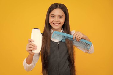 Child with shampoo conditioner. Daily cosmetic care. Teenager hold bottle of hair and skin care. Beauty health and cosmetics