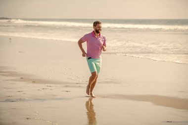 Yaz plajında koşan atletik adam antrenman ve yaz için.
