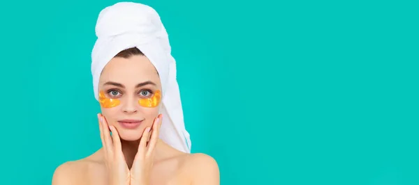Eye patch. young girl has collagen gold eye patches on face with towel. Beautiful woman isolated face portrait, banner with mock up copy space