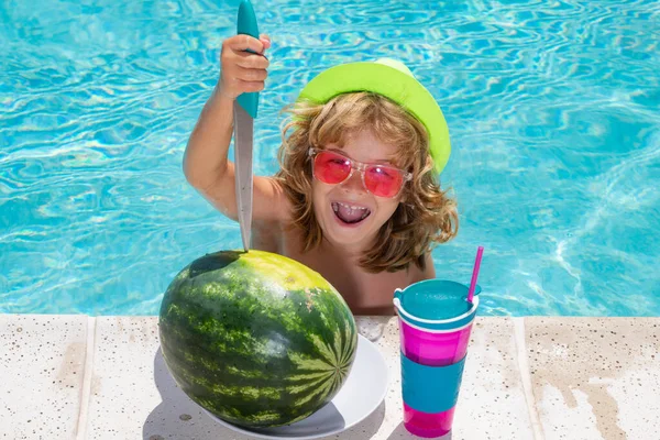 Children with watermelon playing in swimming pool. Kids holidays and summer vacation concept. Summer kids cocktail