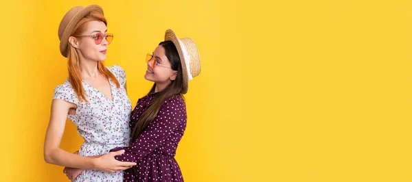 Mother and daughter kid banner, copy space, isolated background. cheerful mother and child in straw hat on yellow background