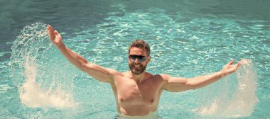 Havuz partisi. Yaz havası konsepti. Yaz tatili. Adam suya gözlük takıyor. İnsan yüzü portresi, kopyalama alanı olan pankart