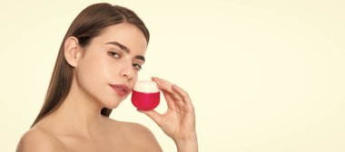 Woman beauty face, close up portrait, isolated banner with copy space. woman use face cream. young girl hold hair mask. lady with skin cream