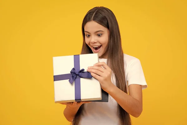 Teenager child with gift box. Present for holidays. Happy birthday, Valentines day, New Year or Christmas. Kid hold present box. Excited teenager, glad amazed and overjoyed emotions