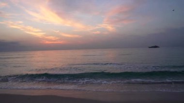 Martılar, gün doğumunda gemi siluetiyle deniz suyunun üzerinde uçuyorlar. Yavaş çekim, tatil..