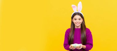 happy easter. child in rabbit costume hold quail painted eggs. time for egg hunt. Easter child horizontal poster. Web banner header, copy space