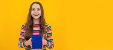 Teenager child with gift box, studio isolated background. Present for birthday, Valentines day. Kid girl with gift, horizontal poster. Banner header with copy space