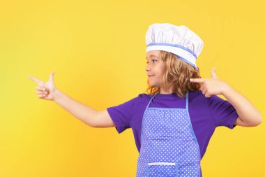 Portrait of little child in uniform of cook. Chef boy isolated on studio background. Cute child to be a chef. Child dressed as a chef hat