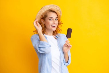 Sarı izole edilmiş arka planda çikolatalı dondurmayla poz veren kız. Yaz kadını