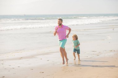 fathers or family day. daddy with kid boy on summer day. dad and child having fun outdoors. childhood and parenting. father and son running on sea beach. family travel weekend and vacation.