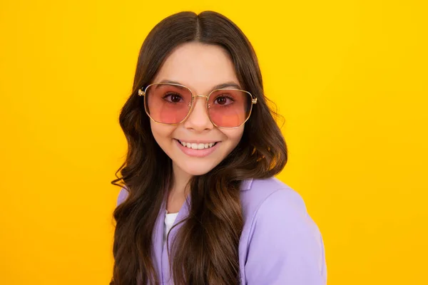 Teenager child with poor eyesight wear sunglasses, looking squinting. Kids glasses. Funny surprised adorable girl in round glasses having astonished shocked facial expression
