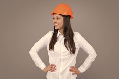 Gri arka planda izole edilmiş kasklı genç ve güzel bir kadın..