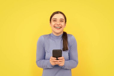 Mutlu bayan akıllı telefondaki mesajlara gülüyor, blog yazıyor..