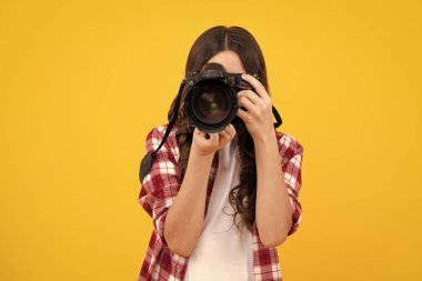 DSR kameralı genç kız fotoğrafçı. Çocuk dijital kamera kullanıyor. Çocuk fotoğrafları. Fotoğrafçılık okulu. Çocuk fotoğrafçı acemi