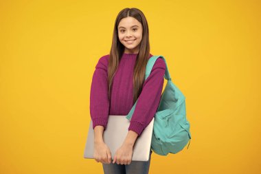 Liseli kız dizüstü bilgisayarını izole stüdyo geçmişinde tutuyor. Okul ve eğitim kavramı. Okul üniformalı ergen kız.