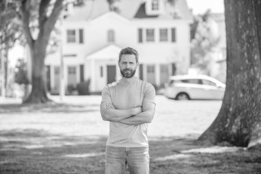 Kendine güveni olmayan adam yeni evin yanında duruyor, ev alıyor..