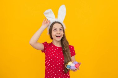 Easter child holidays concept. Happy smiling little teenage girl with bunny ears holding painted easter eggs. Excited face, cheerful emotions of teenager girl