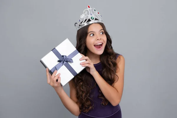 Child with gift present box on isolated background. Presents for birthday, Valentines day, New Year or Christmas. Excited face, cheerful emotions of teenager girl