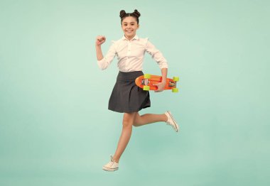 Teenagers youth casual culture. Jump and run. Teen girl with skateboard over isolated studio background. Teenager in fashion stylish clothes