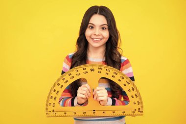 Ergen liseli kız matematik ya da geometri dersi alıyor, boyunu ölçüyor. Ölçmek için matematik hükümdarı. Mutlu pozitif ve gülümseyen okul kızı
