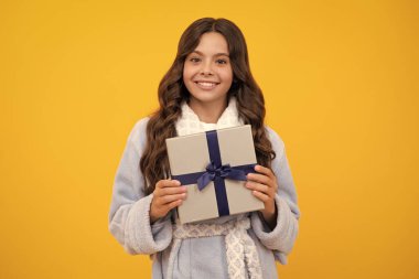 12, 13, 14 yaşlarında elinde Noel hediyesi olan genç bir kızın portresi. Gençler doğum günü hediyesi veriyor.