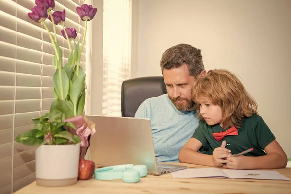 bearded dad or school private tutor teaching boy son with modern laptop, buy online.