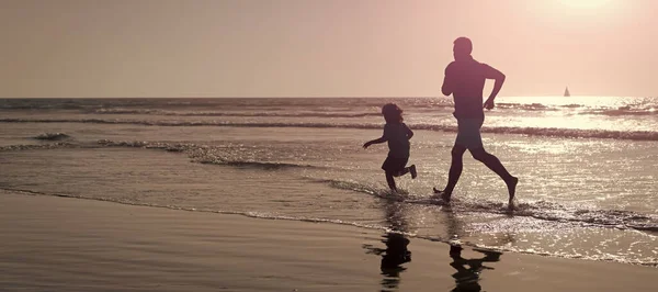Silhouette of father and son run on summer beach outdoor, banner poster with copy space, weekend family day. dad and child have fun outdoors. childhood and parenting