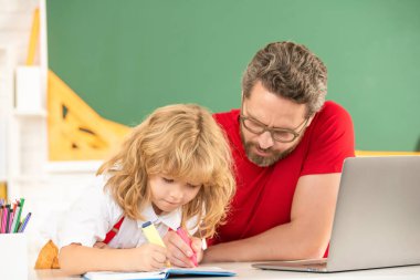 Genç çocuk özel öğretmenle ders çalışıyor. Webinar video dersi. Bilgisayarda online eğitim. Baba ve oğul modern iletişim teknolojisini kullanıyorlar. Aile blogu. çocukluk ve ebeveynlik.