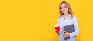 smiling blonde woman with coffee cup and computer on yellow background. Woman isolated face portrait, banner with mock up copy space