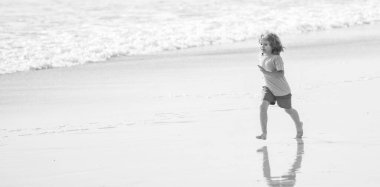 sport child run fast to win in the ocean. morning workout activity. healthy kid running on beach. energetic summer. runner feel freedom. small boy enjoying the morning. active childhood. copy space.