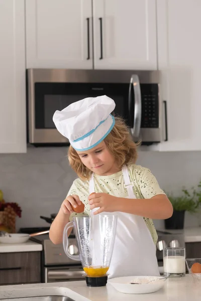 Chef kid cook baking at home kitchen. Kid chef cook cookery at kitchen. Cooking, culinary and kids. Little boy in chefs hat and apron