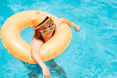 Mutlu çocuk yüzme havuzunda oynuyor. Yaz tatili kavramı. Yaz çocukları sahilde deniz suyunda portre yapar.