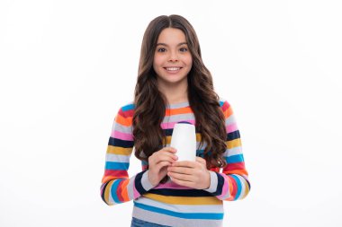 Şampuan kremi kullanan bir çocuk. Günlük kozmetik bakım. 12, 13, 14 yaşlarındaki ergen çocuğun elinde saç ve cilt bakımı şişesi var. Güzellik sağlığı ve kozmetik ürünleri. Mutlu kız yüzü, pozitif ve gülümseyen duygular