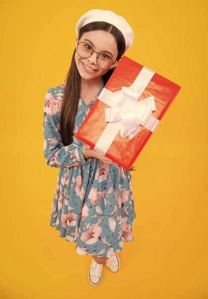 Child with gift present box on isolated background. Presents for birthday, Valentines day, New Year or Christmas. Happy teenager, positive and smiling emotions