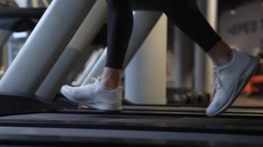 Athletic feet running on fitness treadmill in gym. Treadmill workout. Fitness equipment for gym. Fitness and exercise. Cardio training.
