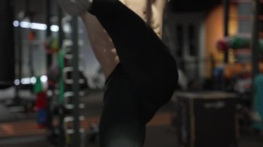 Athlete with fit torso crop view doing hanging leg-lift in fitness gym. Fitness bar exercises. Guy building abs exercising on gym bar. Ab workout. Fitness workout.