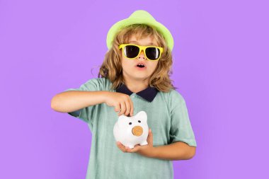 Saving money and piggy bank concept. Boy saving money in a piggybank. Child boy with american dollars money