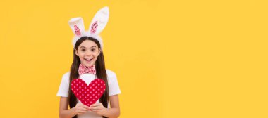 cheerful bunny kid with love heart. happy easter holiday. Easter child horizontal poster. Web banner header of bunny kid, copy space