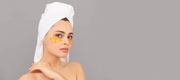 Eye patches, patch under eyes. Beautiful woman isolated face portrait, banner with mock up copy space. the best care. young woman in terry towel use patch. beauty day in spa