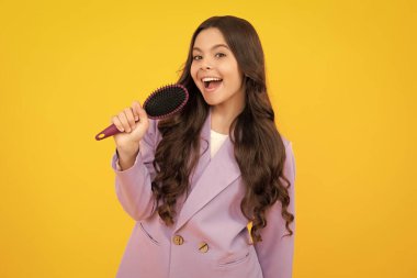 Tarak taramak için uzun saçlı bir çocuk, güzellik. Saç kremi şampuanı. Güzellik salonu. Çocuk saç stili. Mutlu yüz, pozitif ve gülümseyen genç kız duyguları