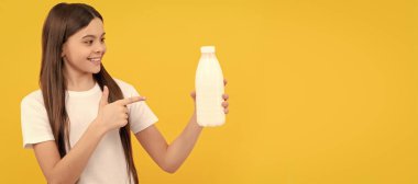 cheerful child point finger on dairy beverage product. teen girl going to drink milk. Horizontal poster of isolated child face, banner header, copy space