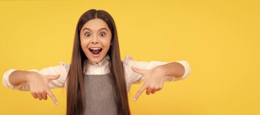 happy teen girl point finger on blank pink paper sheet for copy space, promotion. Child face, horizontal poster, teenager girl isolated portrait, banner with copy space