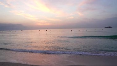 morning beach on sunrise sky with seagulls close to water and ship, summer.