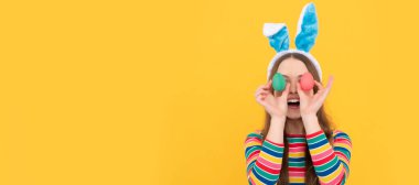 surprised bunny kid. happy easter holiday. funny child hold painted eggs. teenager girl rabbit. Easter child horizontal poster. Web banner header of bunny kid, copy space