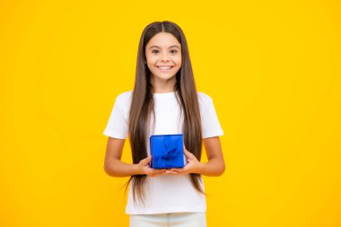 Tişörtlü mutlu bir genç. Hediye kutusu olan ergen bir çocuk. Tatil hediyesi. Mutlu yıllar, Sevgililer Günü, Yeni Yıl ya da Noel. Çocuk hediye kutusunu tut