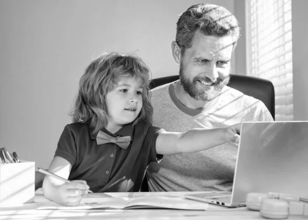 smiling father and son use communication technology at home. family blog. boy do homework with teacher. webinar video lesson. online education on laptop. homeschooling and elearning. back to school.