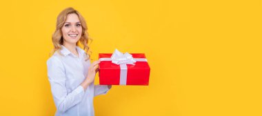 happy woman hold big present box on yellow background. Woman isolated face portrait, banner with mock up copy space