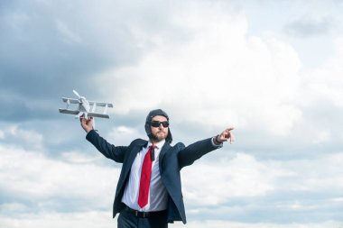 businessman in suit and pilot hat launch plane toy on sky background. opportunity.